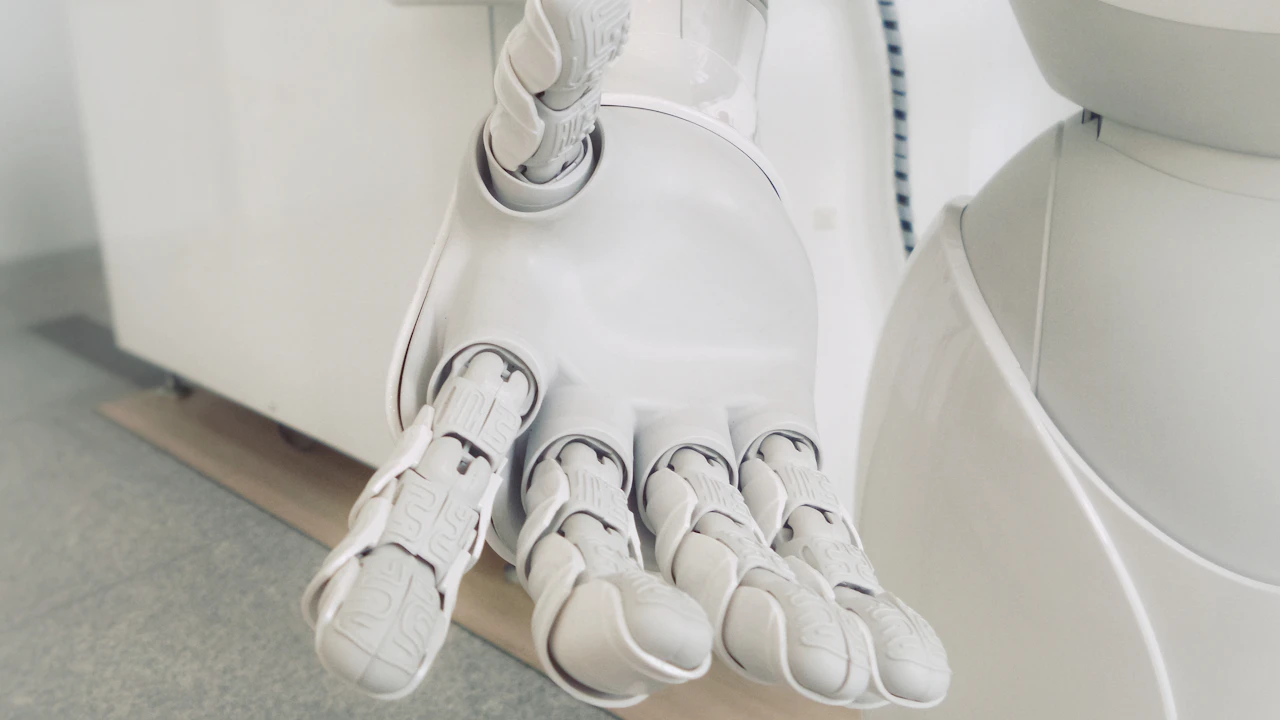 Humanoid robot carrying a tote in a warehouse aisle